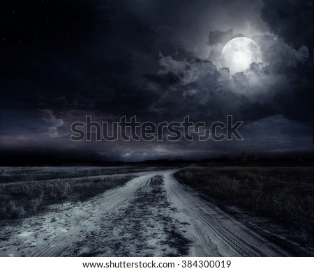 country road at night with large moon