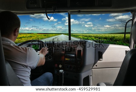 The truck driver on the road among fields highway. business trip