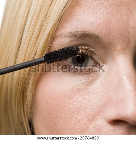 woman putting on mascara