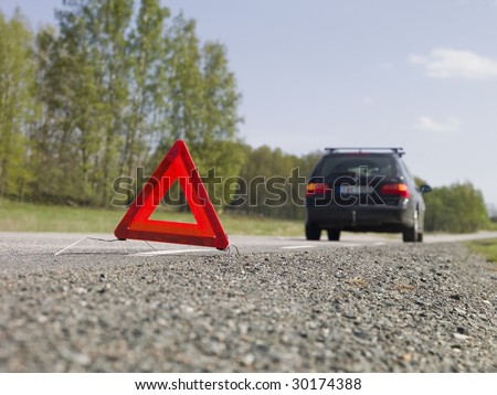 Warning triangle in front of a car breakdown
