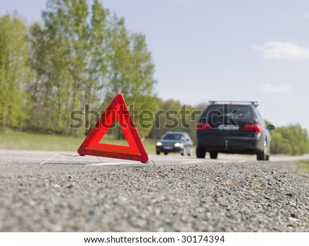 Warning triangle in front of a car breakdown