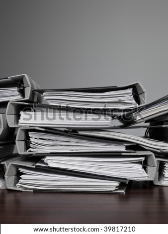 Overwelming number of files stacked on a desk