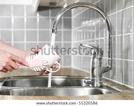 Close up of a human washing a coffee cup