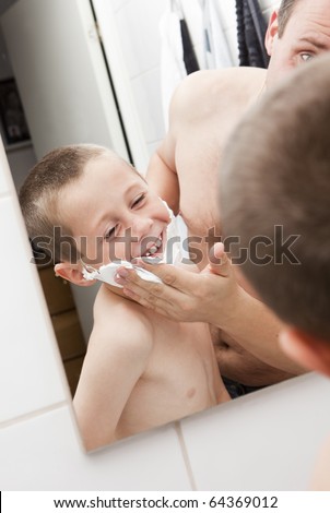 Happy Mature Man shaving in bathroom with his son
