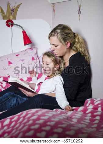 Mother and Daughter storytelling sitting in the bed