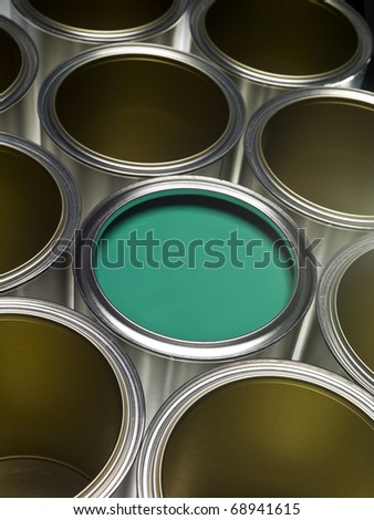 Paint cans full frame with green paint in one of them