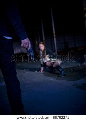 Man treating a woman with a gun at night