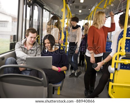 Couple with computer going by bus