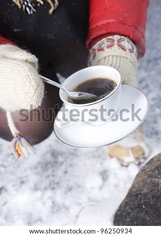 Holding a cup of Coffee with winter gloves