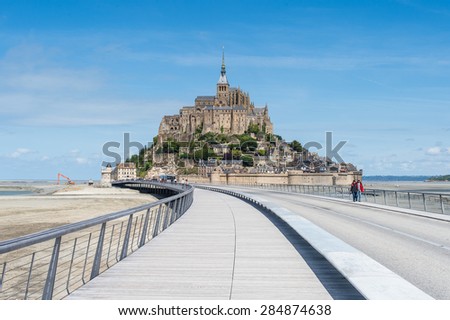 MONT-SAINT-MICHEL, FRANCE - MAY 29, 2015: Tourists walking to the Mont-Saint-Michel on a sunny morning. May 29, 2015 at Mont-Saint-Michel, Brittanie, France.