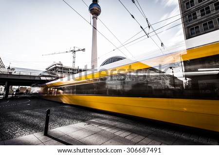 Yellow tram at Berlin Alexanderplatz. In the background you can see the TV tower and the station