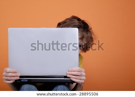 Hiding young man behind the laptop