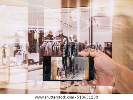 Augmented reality application for retail business concept. Hand holding smart phone with A/R application on screen to finding interested product in the store.