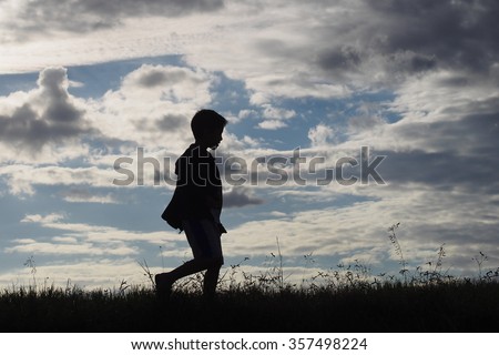 A boy walk along a country road to back his home in the evening of winter : silhouette photo