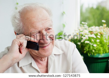 senior man speaking on the phone, enjoying a conversation with somebody