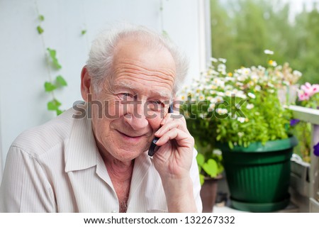smiling senior man speaking on the phone with somebody