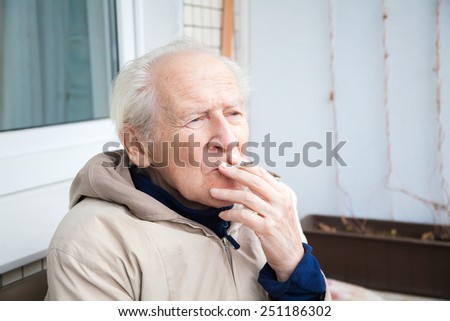 thoughtful old man smoking a cigarette