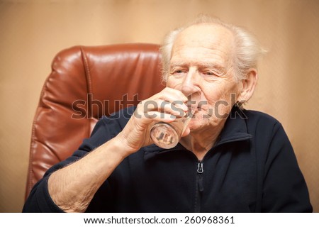 old man drinking a glass of water