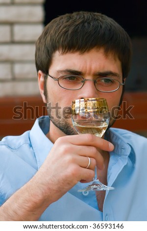 portrait of a man testing and smelling white wine