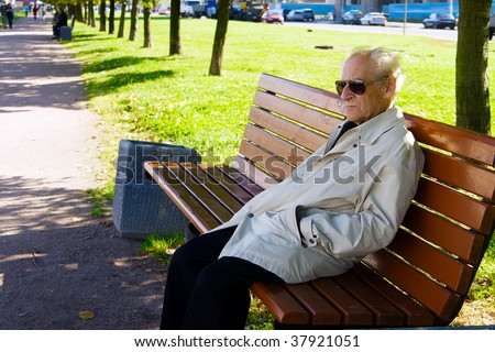 portrait of the old man sitting alone on the bench