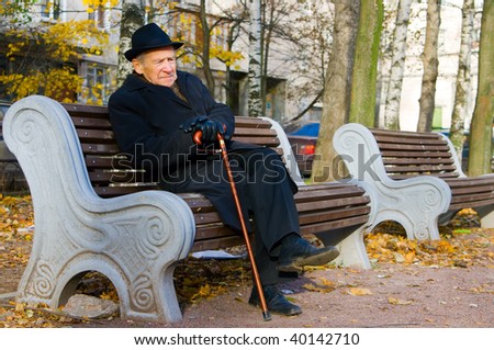 portrait of an old man in a hat sitting on a bench