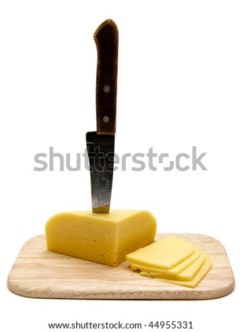 block of cheese with cut pieces on cutting board with a knife, slicing through it, isolated on white background