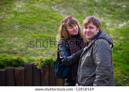 portrait of a couple - she is looking at him and smiling, he is looking straight