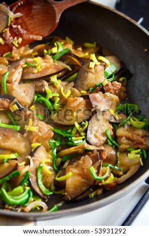 close-up pan with sliced eggplant and green leek, it is preparation of tasty dinner