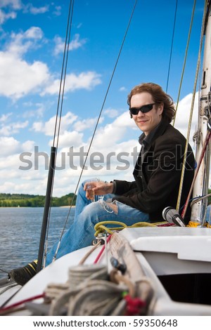 man in sunglasses drinking champagne on the sailboat