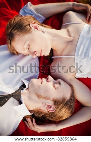 close-up faces of lying man and woman with eyes closed, they are in harmony and love each other, the shot is made from above