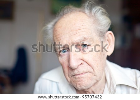 face portrait of an old unhappy frowning senior man