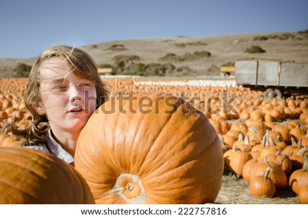 Teenager girl in plaid shirt choosing pumpkins on pumpkin patch. Picture is filtered for instagram retro look.