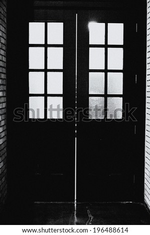 A black door with eight small windows on each side of the door.