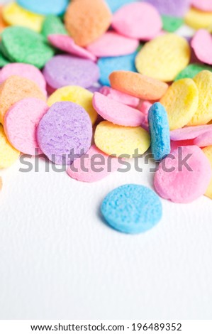 Various pastel colored discs scattered on a white surface.