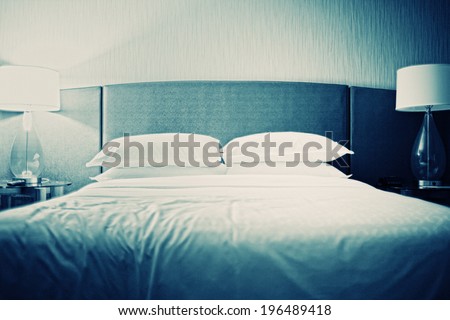 A bed with white sheets and white pillows.