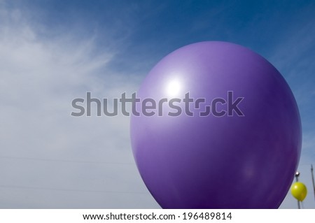A purple balloon with a bit of blue sky in the background.