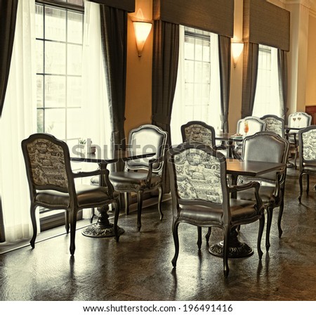 The dining room of a formal restaurant with several tables for two.