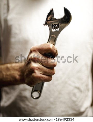A person holding a wrench in their hand.