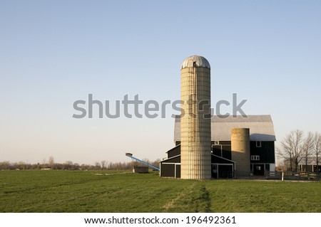 A barn with two silos and another building beside it.