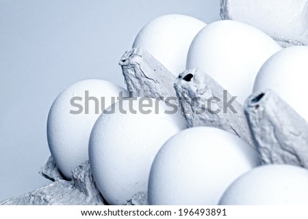 Seven white eggs contained in an egg carton.