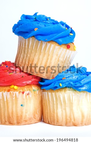 Cupcakes with bright blue and red icing and colored sprinkles.