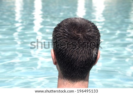 The back of a person's head as they look at the water.