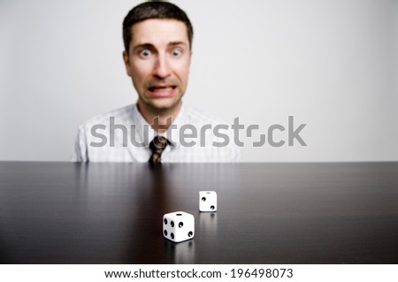 A man staring at two dice on a table.