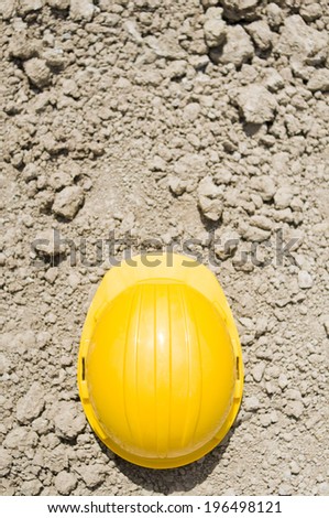 A single yellow hard hat sitting on the ground.