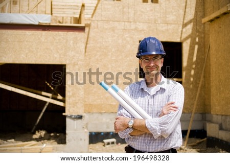 A construction worker and a partly built house.
