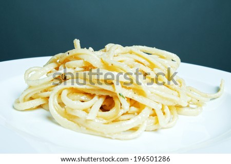 Noodles sitting on a plate with a teal background.