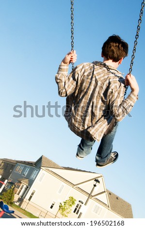 A child going high in the air on a swing.