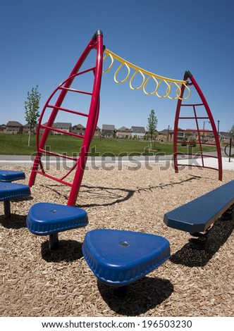 Yellow monkey bars and benches in a playground.
