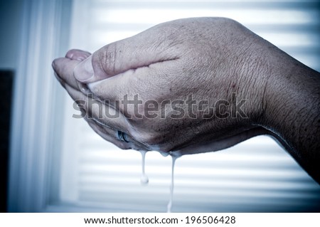 Two hands clasped holding suds that are dripping.