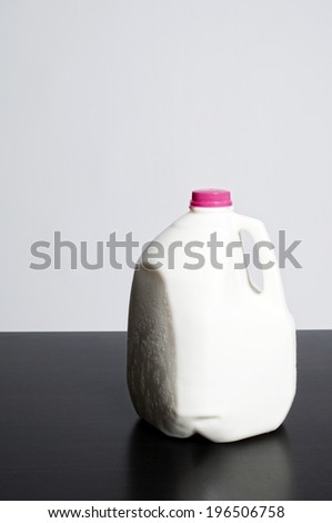 A gallon of milk with a red cap.